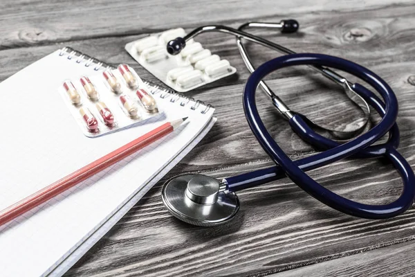 Stetoscopio e oggetti medici su scrivania in legno — Foto Stock