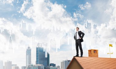 evin çatısında duran işadamı 