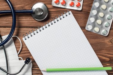 Steteskop ve ahşap masa üzerinde tıbbi nesneleri