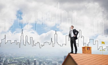 evin çatısında duran işadamı 