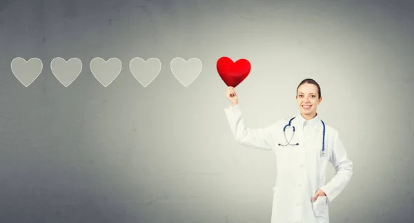 Médico feminino segurando símbolo coração — Fotografia de Stock