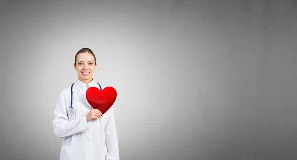 Female doctor holding heart symbol — Stock Photo, Image