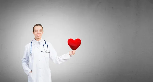 Médico feminino segurando símbolo coração — Fotografia de Stock