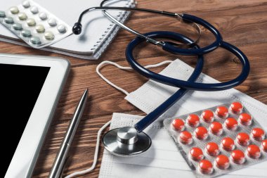 Steteskop ve ahşap masa üzerinde tıbbi nesneleri