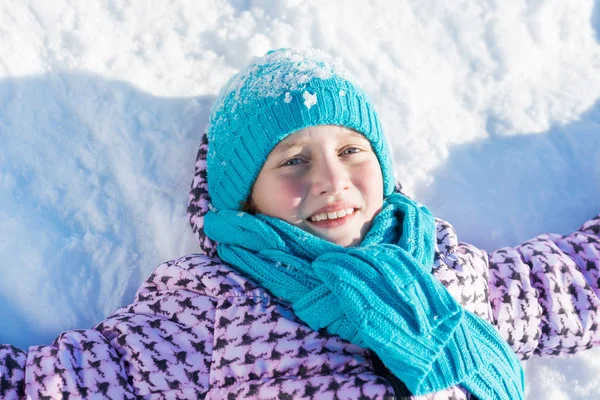 Menina deitada na neve — Fotografia de Stock