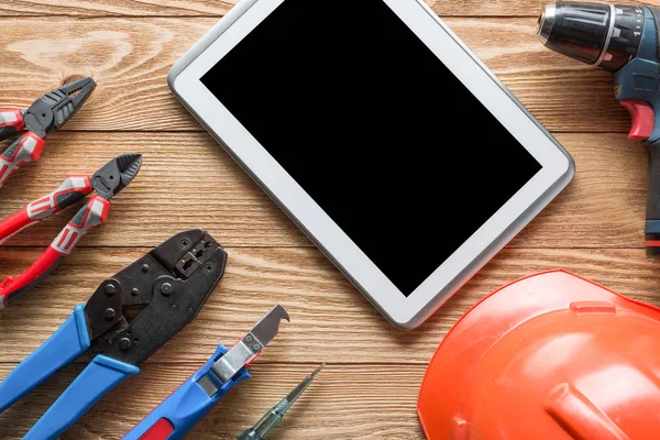tools of builder and tablet pc on table