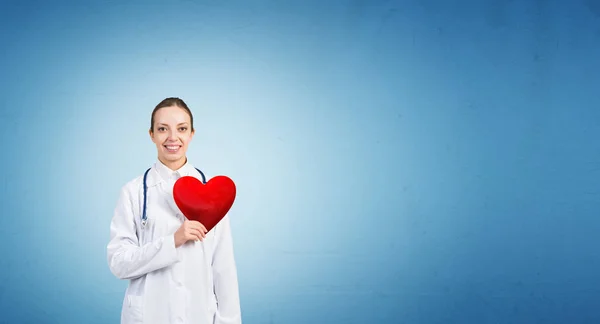 Médico feminino segurando símbolo coração — Fotografia de Stock