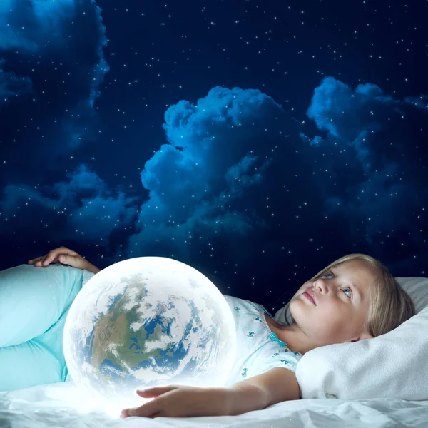 Meisje in bed met Earth planet — Stockfoto