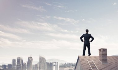 evin çatısında duran işadamı