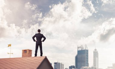 evin çatısında duran işadamı