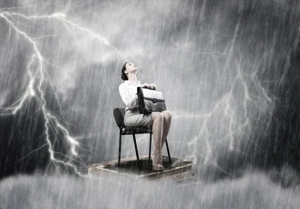 Businesswoman sitting under rain — Stock Photo, Image