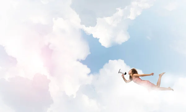 Kvinna med MegaFon flyger högt i sky — Stockfoto