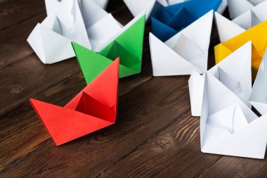 İş liderlik kavramı ile beyaz ve renkli kağıt tekneler ahşap masa üzerinde