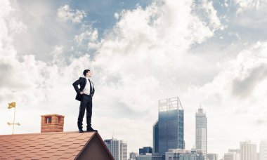 evin çatısında duran işadamı