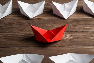 İş liderlik kavramı ile beyaz ve renkli kağıt tekneler ahşap masa üzerinde