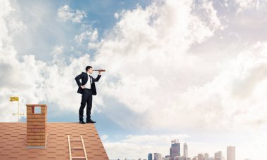 evin çatısında duran işadamı