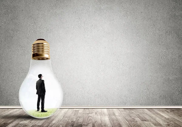 Businessman inside of light bulb — Stock Photo, Image