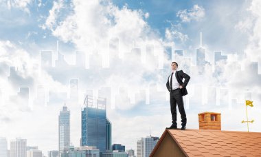 evin çatısında duran işadamı 