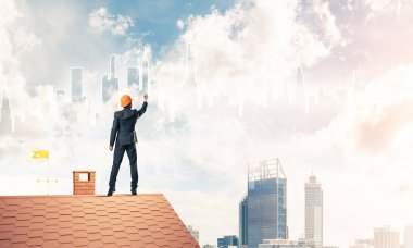 Mühendis adam evin çatısında ayakta