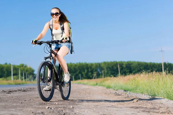 Frau mit Rucksack auf Fahrrad unterwegs — Stockfoto