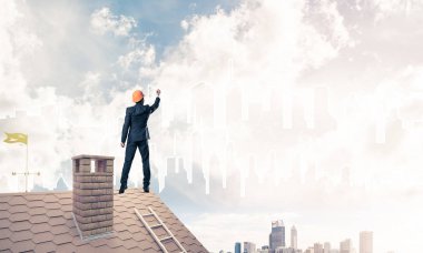 Mühendis adam evin çatısında ayakta