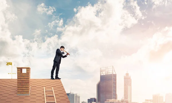 Бізнесмен стоїть на даху будинку — стокове фото