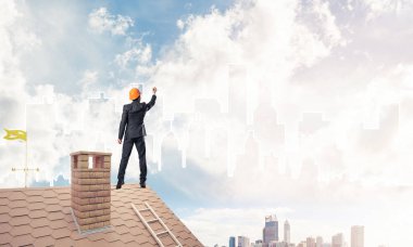 Mühendis adam evin çatısında ayakta