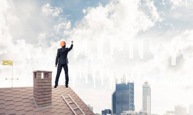 Mühendis adam evin çatısında ayakta