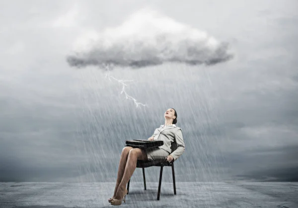 Businesswoman sitting under rain — Stock Photo, Image