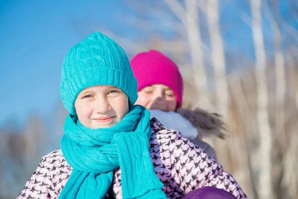 Cute girls riding sled at wintertime — Stock Photo, Image