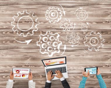 Bir grup ellerinde aygıtlarla üç insan