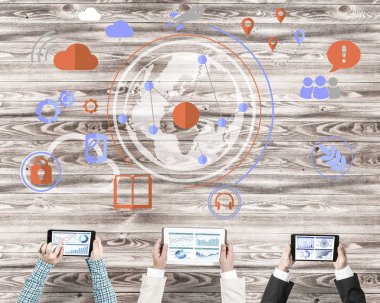 Bir grup ellerinde aygıtlarla üç insan