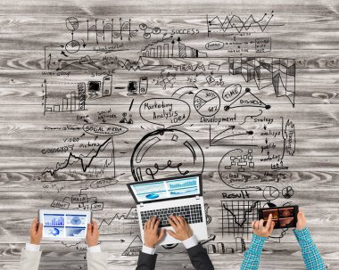 Bir grup ellerinde aygıtlarla üç insan