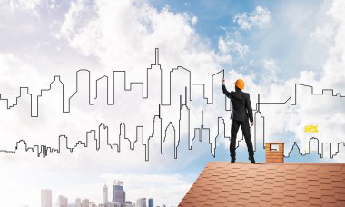 Erkek mimar mavi gökyüzüne modern şehrin siluetini çizer. Karışık ortam