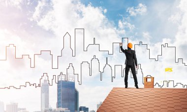 Erkek mimar mavi gökyüzüne modern şehrin siluetini çizer. Karışık ortam