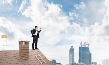 evin çatısında duran işadamı