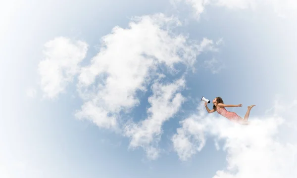Mulher com megafone voando alto no céu — Fotografia de Stock