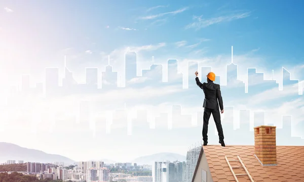 Мужчина стоит спиной к крыше дома — стоковое фото