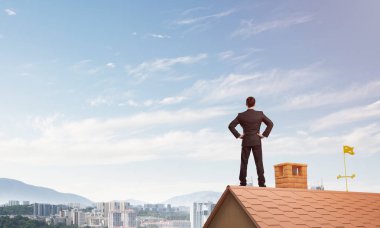 evin çatısında duran işadamı 