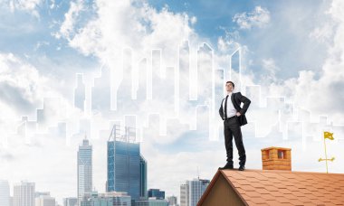 evin çatısında duran işadamı 