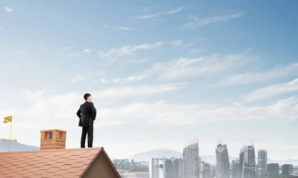 Zakenman staande op het dak van het huis — Stockfoto