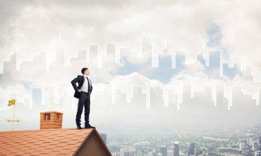evin çatısında duran işadamı 