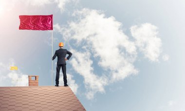 evin çatısında duran işadamı 