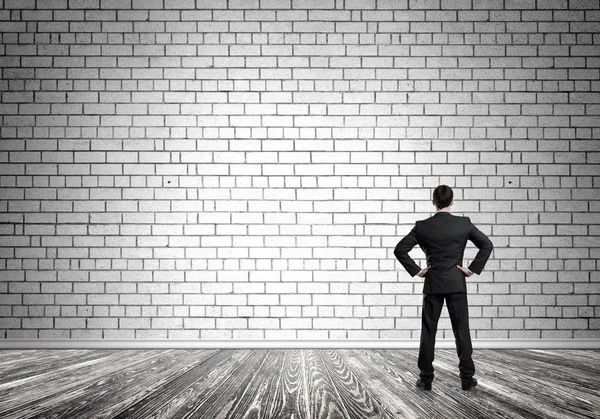 Uomo d'affari guardando muro di cemento bianco — Foto Stock