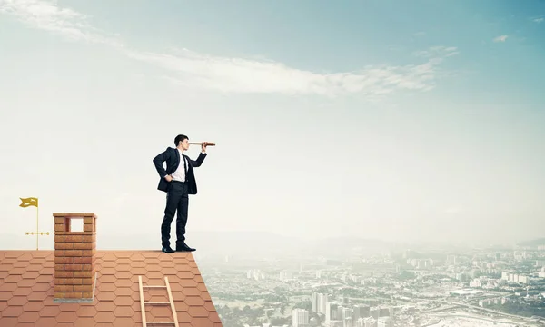 Empresário de pé no telhado da casa — Fotografia de Stock