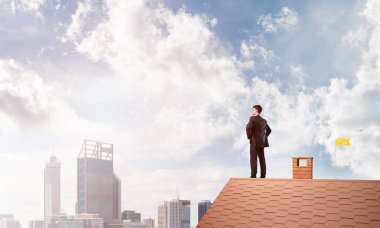 evin çatısında duran işadamı