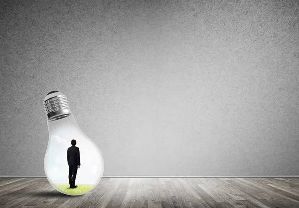 Businessman inside of light bulb — Stock Photo, Image