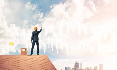 adam evin çatı sırt ile ayakta