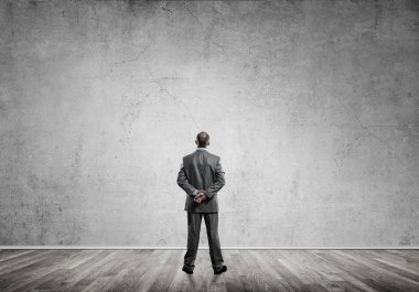 Boş beton duvara bakarak işadamı