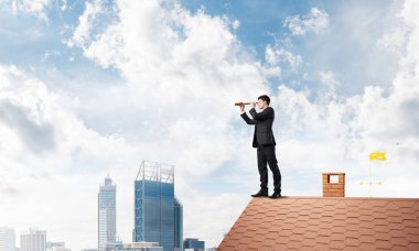 evin çatısında duran işadamı